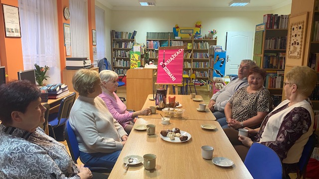 Uczestnicy klubu siedzą przy stole