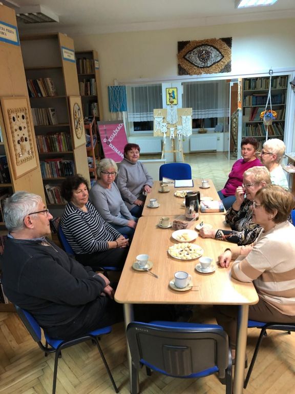 Uczestnicy spotkania Dyskusyjnego Klubu Ksiażki w Dylakach siedzą przy stołach i rozmawiają o książce "Nie pamiętam Cię, córeczko" Danki Brown