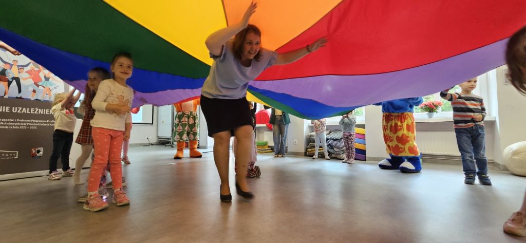 Kobieta oraz dzieci przebiegają pod chustą Klanzy.