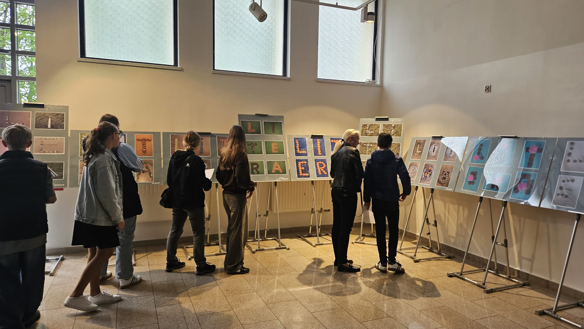 Kilku gości ogląda wystawę nagrodzonych prac konkursowych.