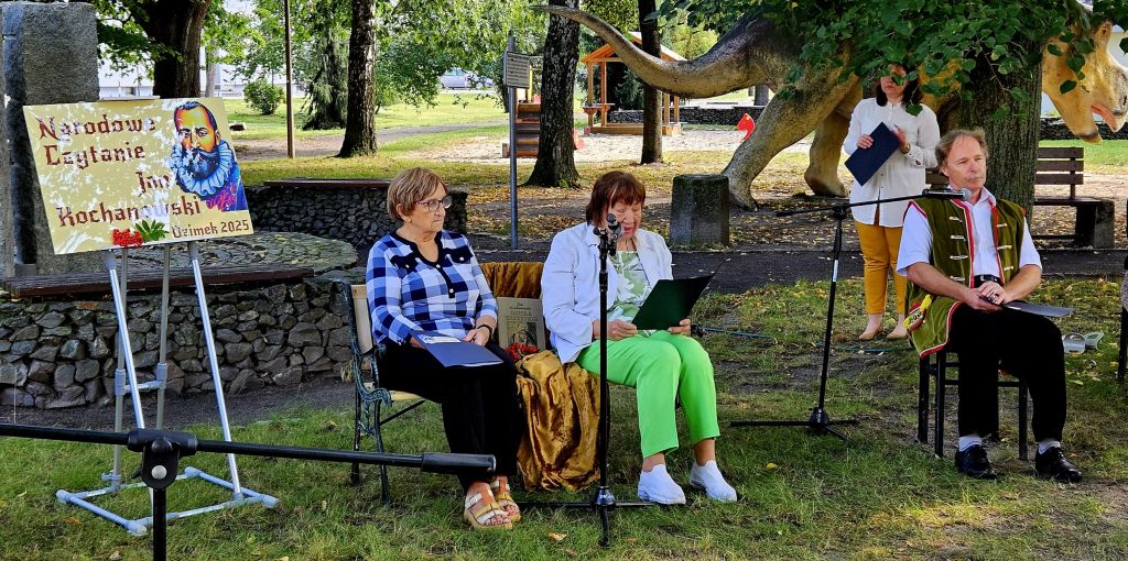 Dwie kobiety siedzą na ławce i czytają do mikrofony utwory Jana Kochanowskiego