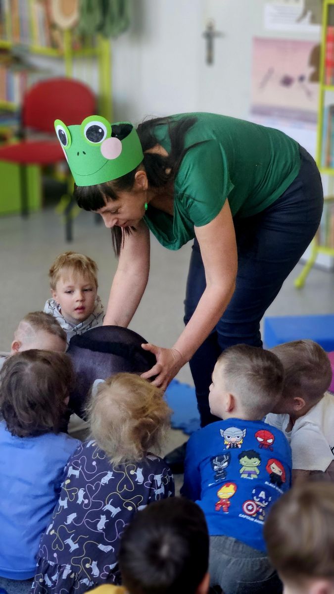 Bibliotekarka pokazuje dzieciom jak wygląda kijanka