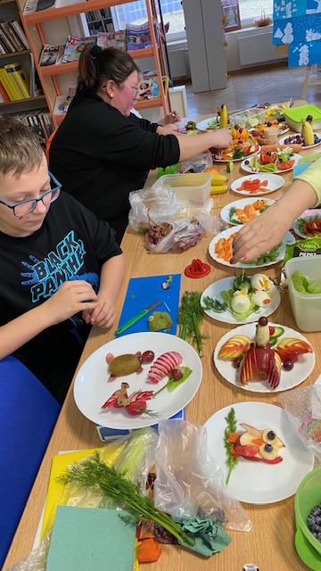 Uczestnicy warsztat&oacute;w pracują przy stole