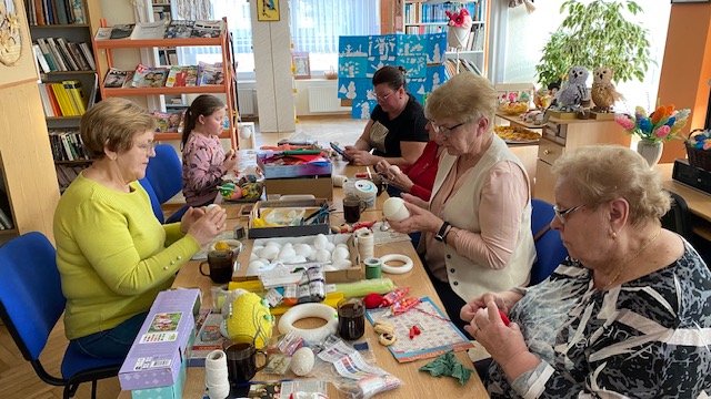 Uczestnicy warsztat&oacute;w pracują przy stole