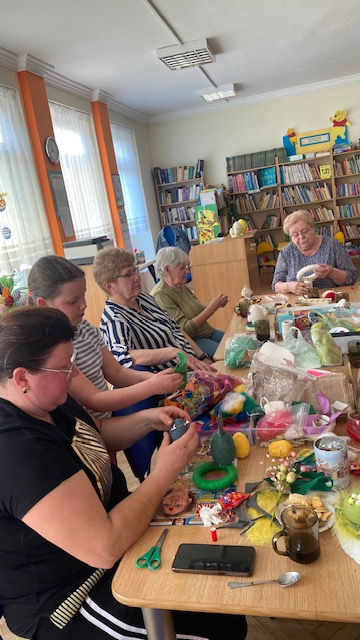 Uczestnicy warsztat&oacute;w pracują przy stole