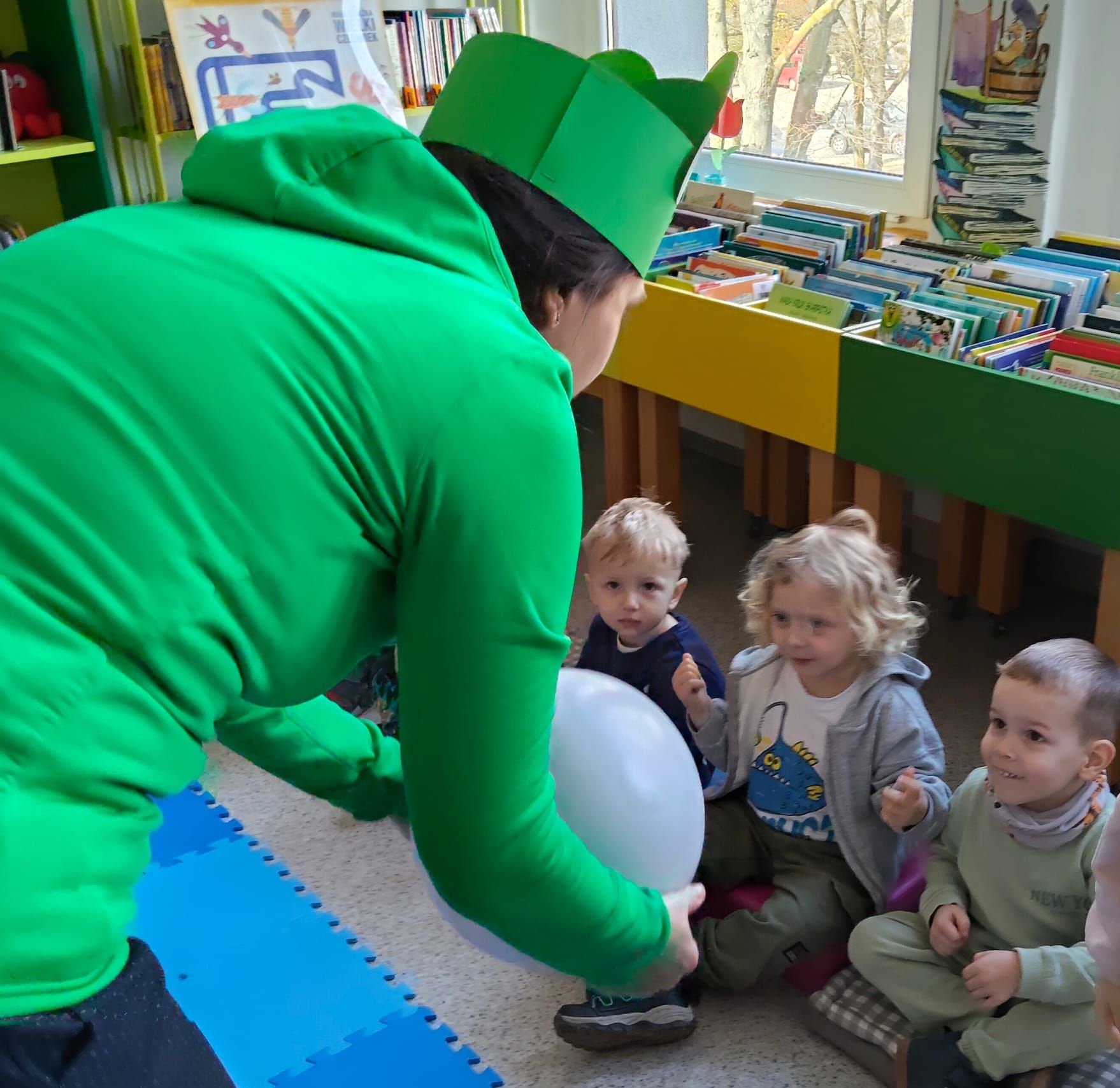 Pani rzuca piłeczkę do dziecka.