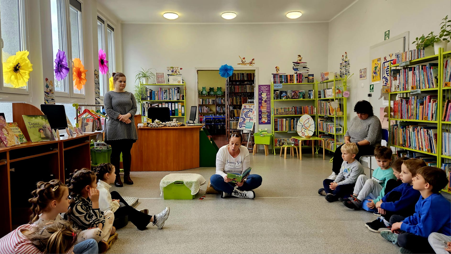 Biblioterka czyta grupie przedszkolak&oacute;w wiersz "Jajko"  Jana Brzechwy.