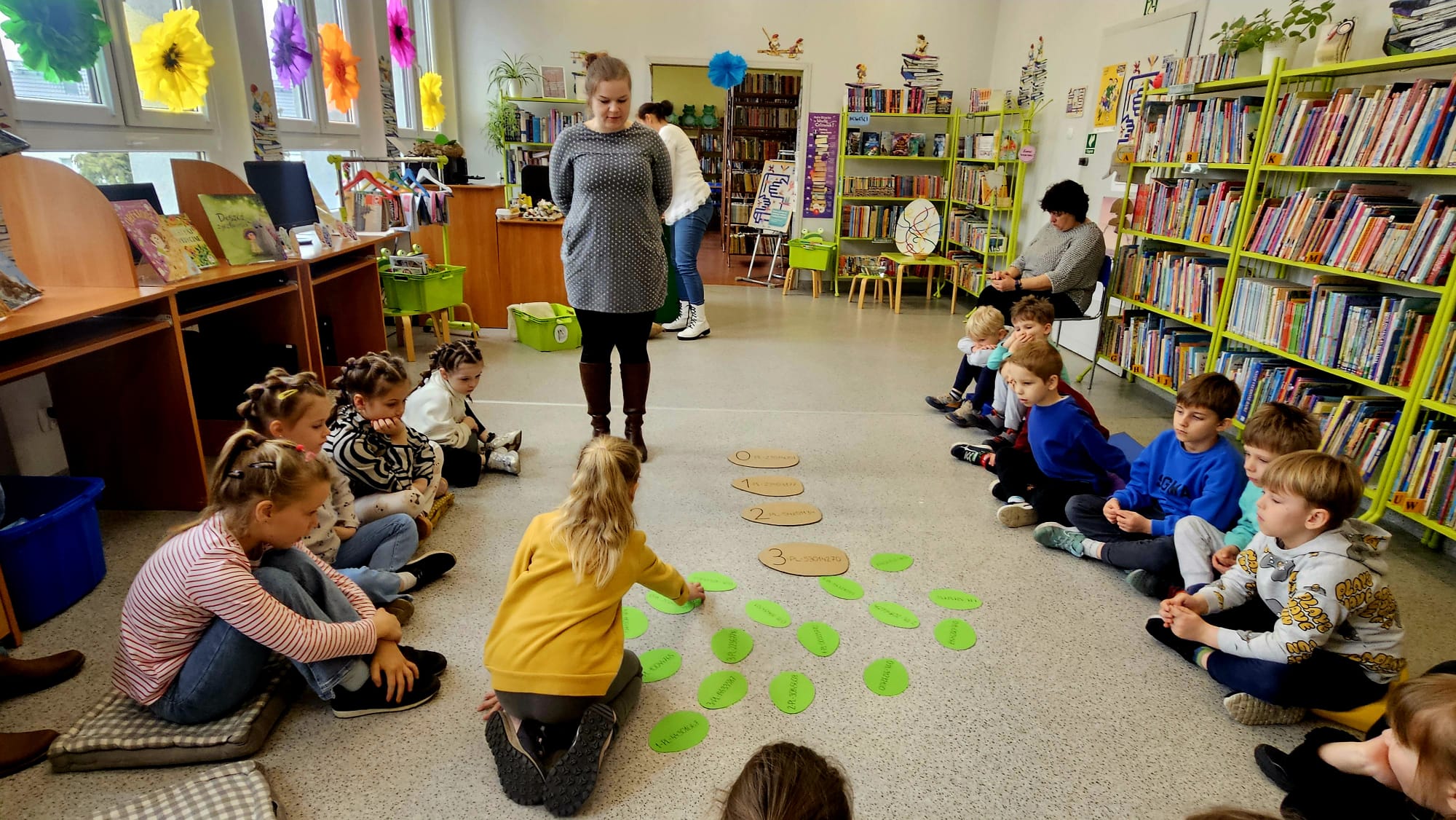 Dziewczynka segreguje papierowe jajka według kod&oacute;w umieszczonych na ich skorupkach.