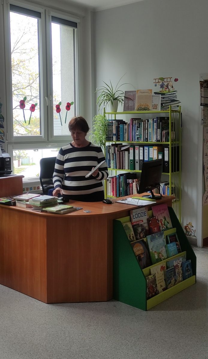 Bibliotekarka prezentuje skaner- nowowczensy spos&oacute;b zapisywania książek w systemie bibliotecznym.