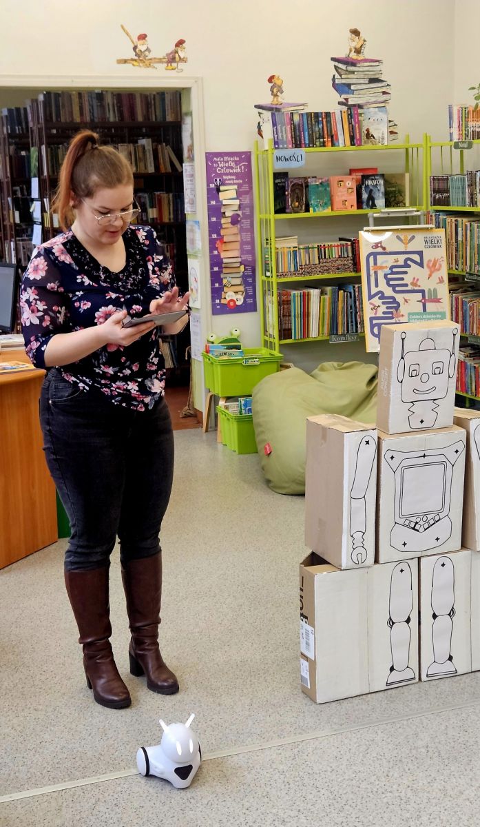 Bibliotekarka pokazuje przedszkolakom umiejętności robota