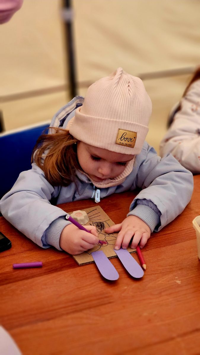 Dziewczynka wykonuje kartkę z zającem.