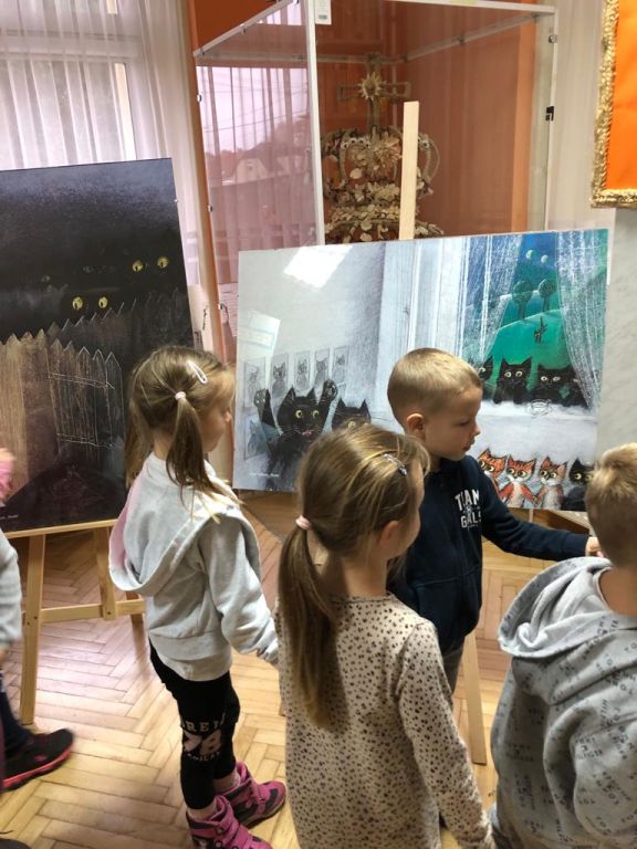 Przedszkolaki oglądają wystawę ilustracji J&oacute;zefa Wilkonia